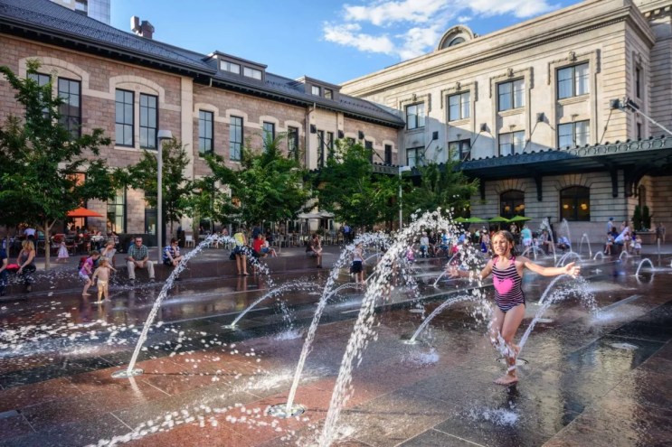kid plays in splash fountains