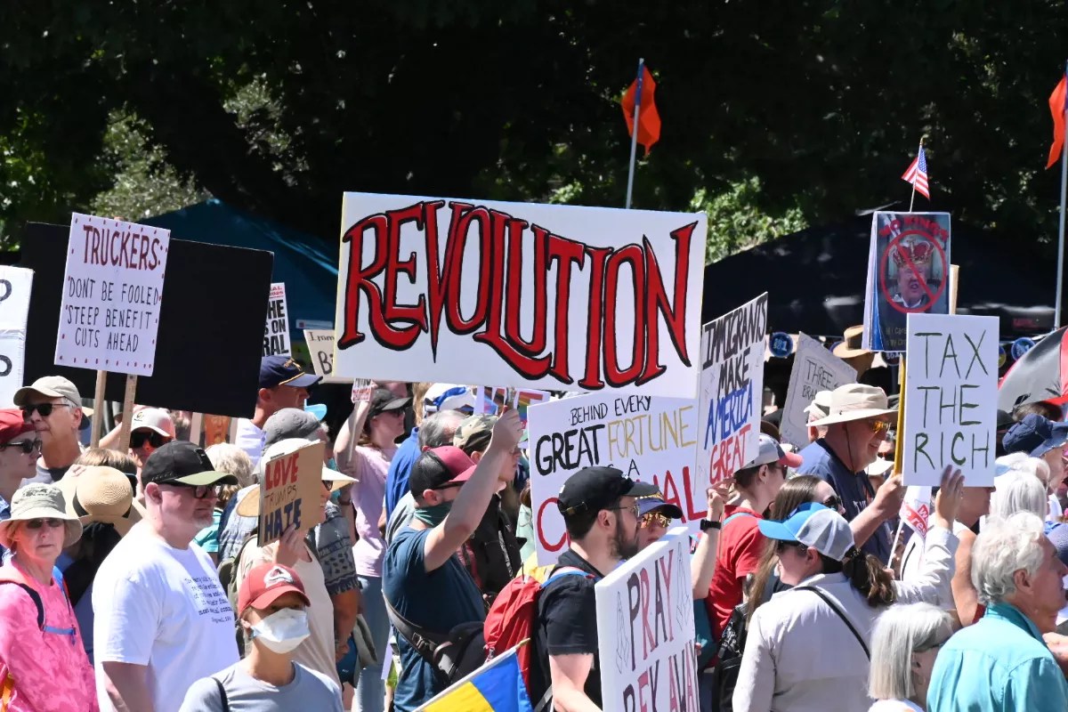 Protesters march and hold signs, one reading "revolution."