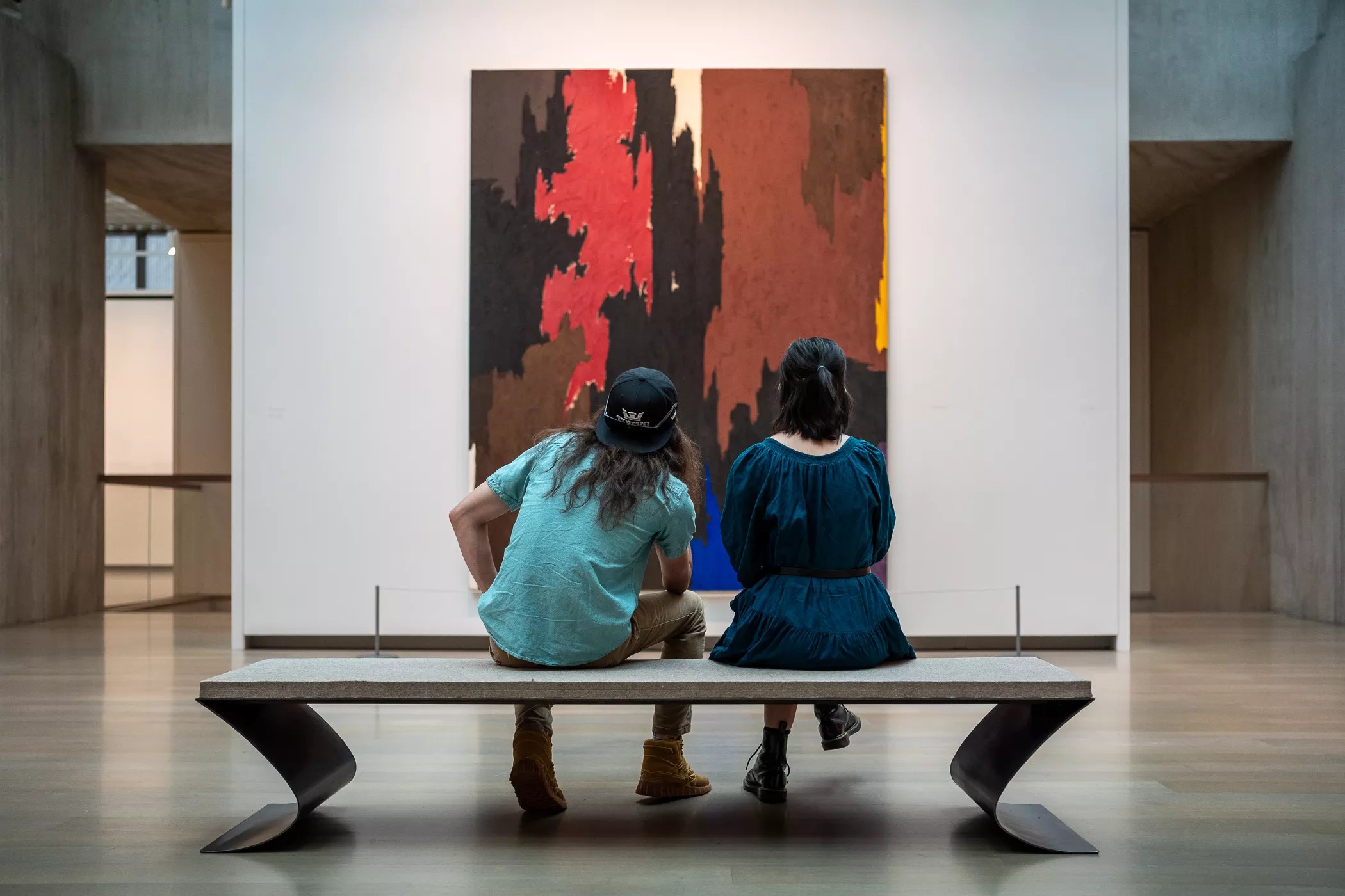 people sit on a bench and look at art