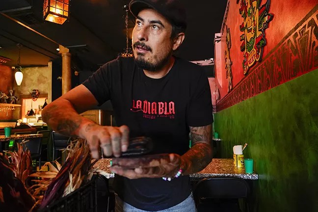 man in a black t-shirt holding corn